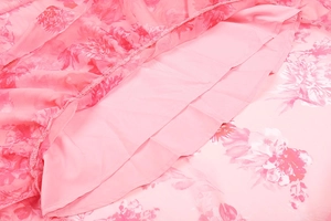 Detail of pink floral chiffon dress showing premium stitching and fabric layering