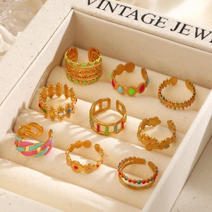 Collection of colorful enamel open rings in gold finish displayed in a vintage jewelry box