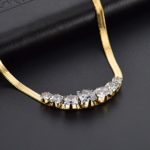 Elegant gold snake chain necklace featuring seven square cubic zirconia stones on black leather