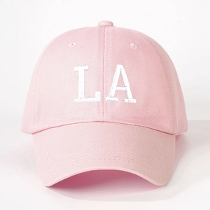 Detail of pink cotton baseball cap with white LA embroidery and curved brim