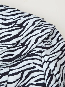Gros plan détaillé sur le tissu à motif zèbre avec texture sergée et drapé élégant
