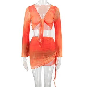 Detailed view of the orange tie-dye mesh long sleeve V-neck top and drawstring skirt set