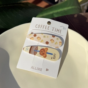 Detail of coffee and dessert themed metal hair clips with cute lettering on display card