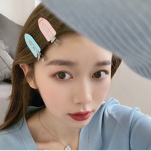 Close-up of pink and blue leaf-shaped creaseless hair clips worn on the model side hair