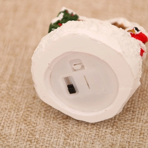 Detailed base view of Christmas resin cottage showing battery compartment and light switch