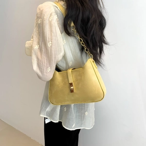 Retro yellow suede shoulder bag with gold chain strap and square metal buckle on model