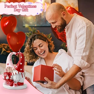 Close-up of a pair of Valentine gnomes holding a red heart with love text on table