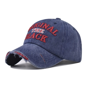 Detail of distressed navy denim baseball cap with red THE BLACK embroidery and frayed brim