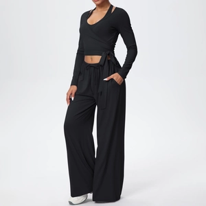 Détail d'un ensemble de yoga noir comprenant un haut croisé à manches longues et un pantalon large