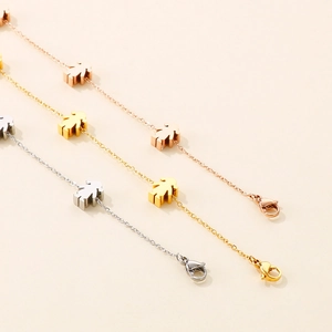Detailed view of three stainless steel bracelets with cute girl charms in gold and rose gold