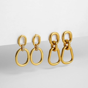 Detail of 18K gold double hoop earrings with cubic zirconia on white display stand