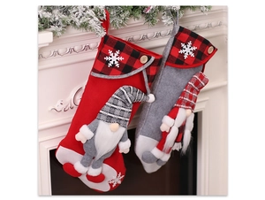 Detail of red and grey gnome Christmas stockings with snowflake hanging by a fireplace