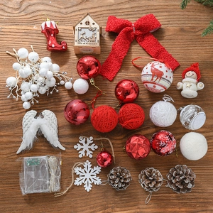 Christmas tree decoration set with red baubles, LED lights, pine cones, and bows on wood