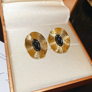 Detailansicht der Vintage-Goldohrringe mit schwarzem Stein in einer edlen Schmuckschatulle
