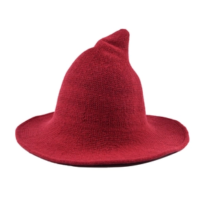 Detailed knit texture of a dark red pointed witch hat with thick woolen weave design