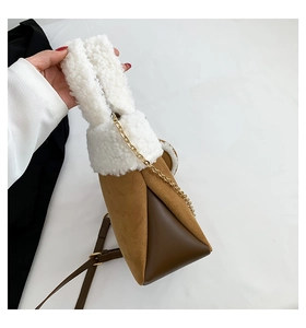 Detail of brown faux suede bucket bag with white faux shearling trim and metal chain