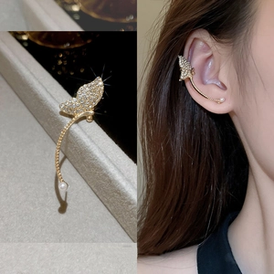 Detailed view of gold butterfly ear cuff with sparkling zircons and a white pearl accent