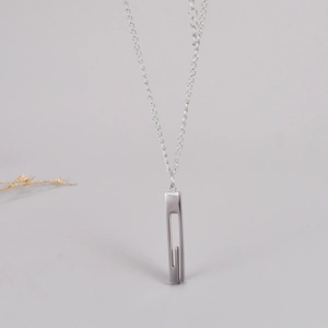 Minimalist silver stainless steel bar necklace with geometric hollow pendant on grey background