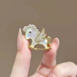 Golden rocking horse brooch with white mother of pearl and sparkling crystals