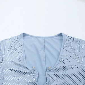 Nahaufnahme des V-Ausschnitts mit silbernen Pailletten auf einem hellblauen Kleid