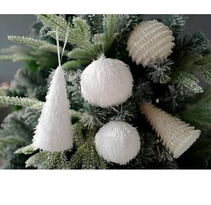 Detail of white plush foam balls and cone ornaments hanging on green Christmas tree branch