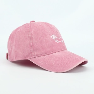 Close-up of pink washed cotton baseball cap featuring white dachshund dog embroidery detail