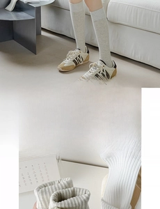 Detail view of light grey cotton knee-high socks featuring soft ribbed texture and dual-needle craft