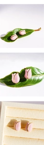 Macro detail of tulip flower bud earrings with pink enamel finish and golden metal borders
