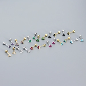 Macro shot of S925 silver clover stud earrings in gold and silver with colorful gems