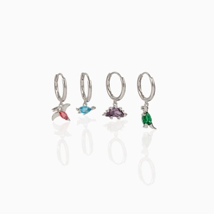 Detailed close-up of four silver dinosaur hoop earrings with colorful zircon stones