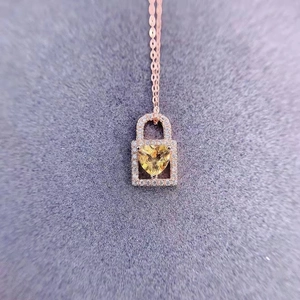 Macro shot of rose gold heart lock pendant with yellow crystal and pavé diamonds