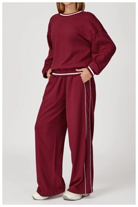 Détail de l'ensemble de survêtement bordeaux avec rayures blanches sur les manches et le pantalon