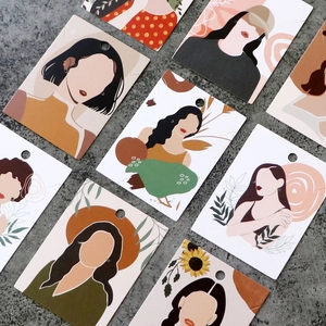 Macro view of colorful printed jewelry display cards featuring modern female illustrations