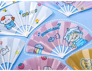 Detail view of colorful cartoon plastic folding fans with HAPPY and sunshine prints