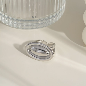 Macro detail of minimalist silver open ring showing sleek double oval design and texture