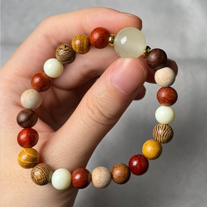 Close-up of a multi-color beaded bracelet with lion carving and wooden bamboo texture