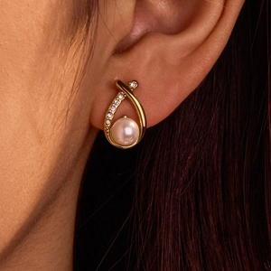 Close-up of gold-plated stainless steel drop earrings with baroque pearls and fine crystals