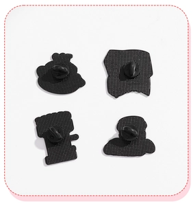 Detail view of four black rubber clutches for coffee badges with durable pin backs
