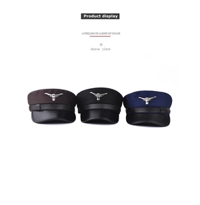 Detailed view of sailor caps in brown, black and navy blue with metal bull emblem