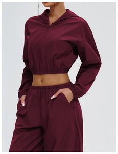 Detail of dark red outdoor sun protection jacket with hood and elasticated hemline