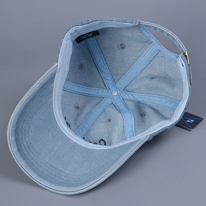 Detail view of denim baseball cap interior with reinforced seams and adjustable metal buckle