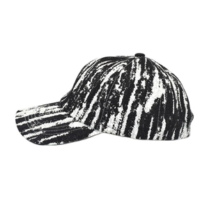Close-up of a tie-dye baseball cap featuring black and white abstract brushstroke patterns