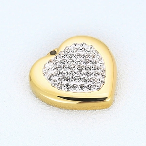 Golden heart pendant with sparkling zircons on a white textured background