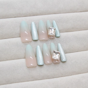 Handmade gradient press-on nails in pink and mint green with rhinestones and cat-eye finish