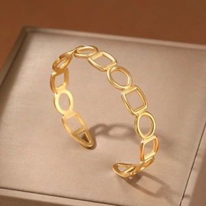 Golden geometric hollow cuff bracelet with matte texture on premium display box