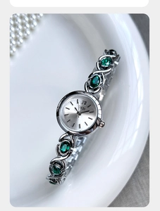 Vue détaillée d'une montre bracelet Gedi argentée ornée de gemmes vertes et cadran minimaliste