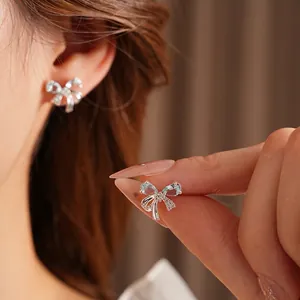 Silver bow stud earrings with light blue teardrop stones and white zircon details