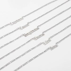 Silver zodiac necklaces featuring Old English font pendants on Figaro chains