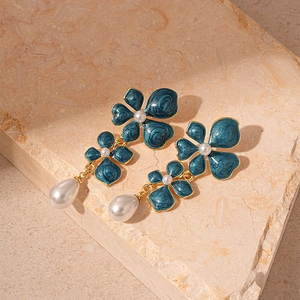 Detail of vintage flower drop earrings with blue enamel petals and white pearls