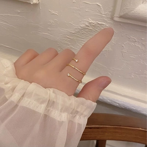 Close-up of golden 925 silver triple ring with zircon on hand with minimalist aesthetic